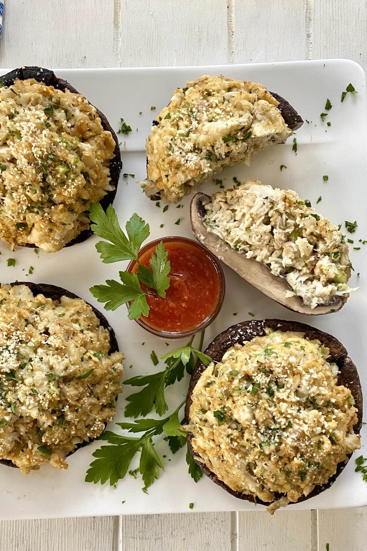 4 crab stuffed mushrooms with cocktail sauce.