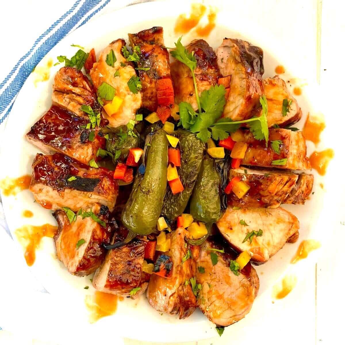 sliced pork tenderloin with grilled peppers and cilantro.