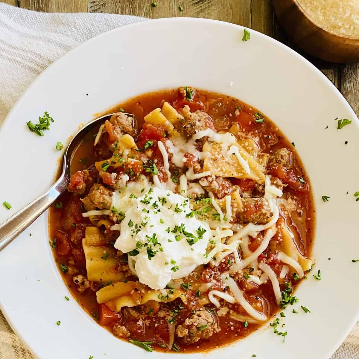 bowl of tomato based lasagna soup topped with ricotta cheese