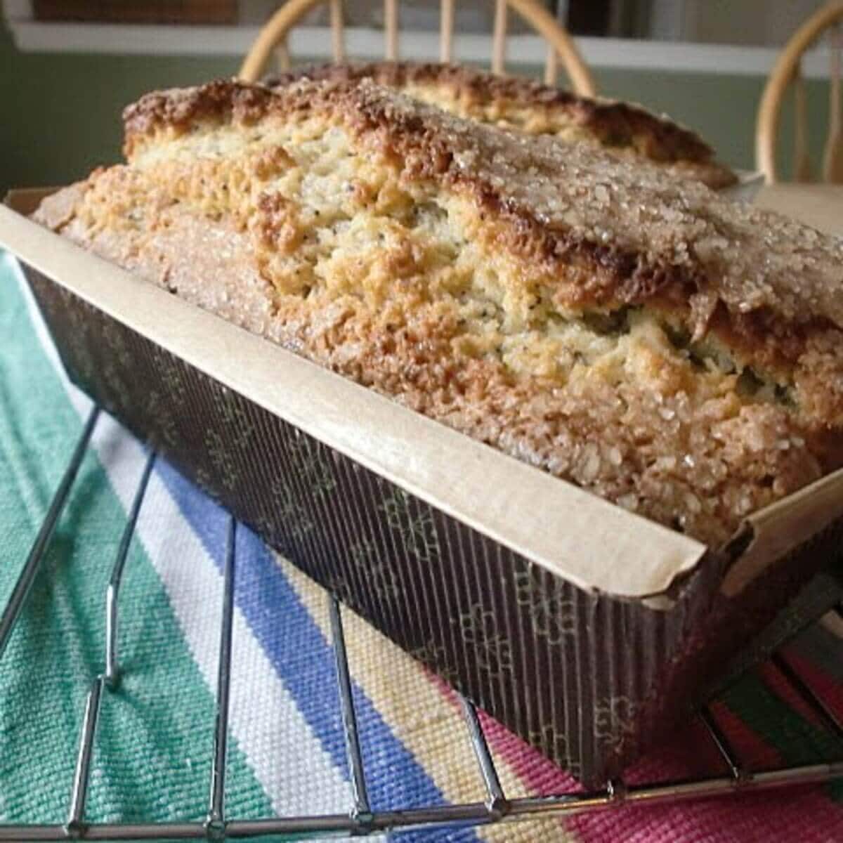 A loaf of poppy seed bread on a table.