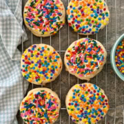 6 sugar cookies with rainbow sprinkles on a cooling rack