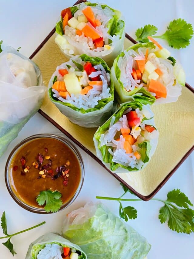 Fresh Vietnamese spring rolls cut in half with peanut sesame dipping sauce.