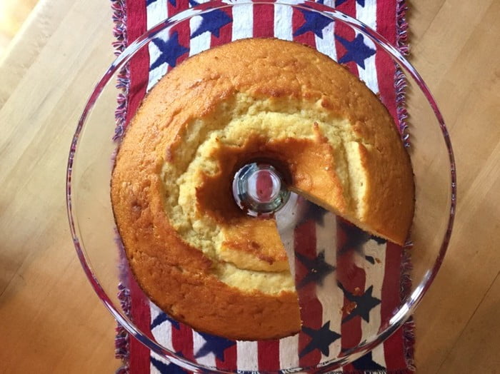 pound cake with a slice cut out on a glass stand