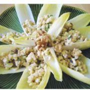 Endive leaves stuffed with walnuts and parmesan on a green plate.