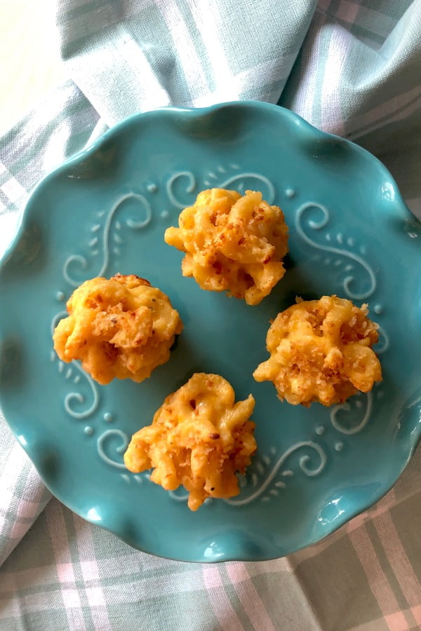 4 mac and cheese bites on teal colored plate
