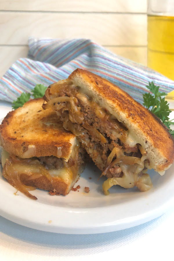 Patty melt cut in half with a cold beer