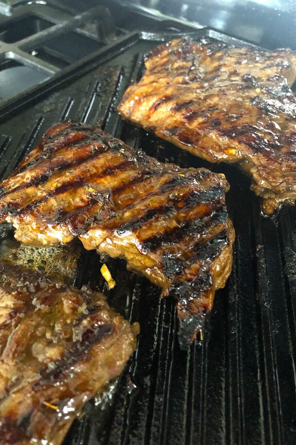 Grilling skirt steaks on a grill pan.