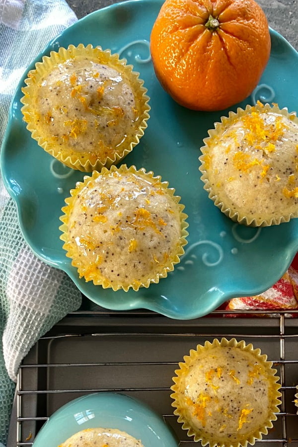 3 muffins on a teal cake stand with an orange