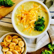 cup of broccoli and cheese soup with oyster crackers