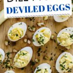 Stuffed eggs with dill pickles on a board.