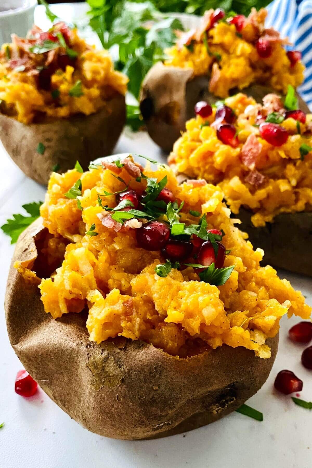 2 stuffed sweet potatoes topped with pomegranate arils.