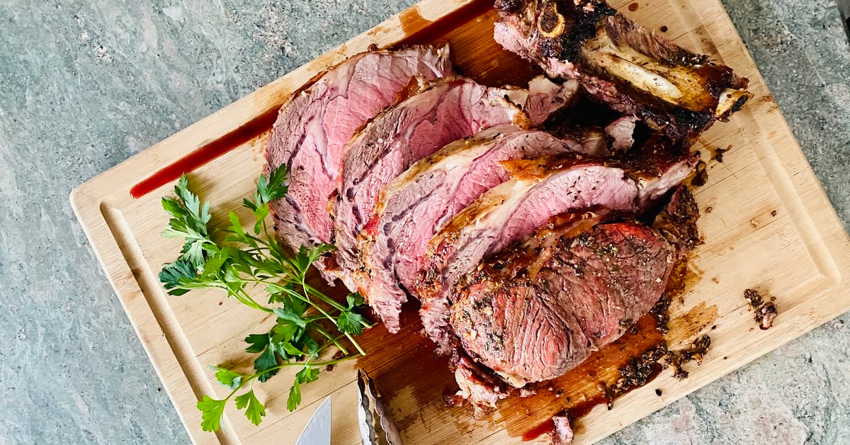 A sliced prime rib on a cutting board.