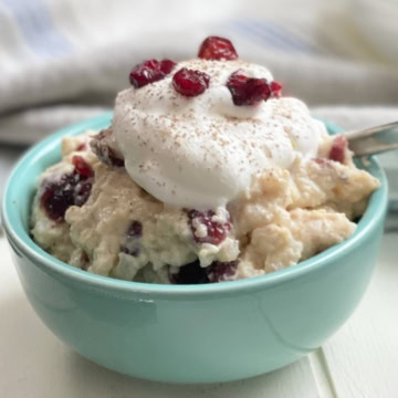 A bowl of stovetop rice pudding with whipped cream.
