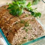 a sliced turkey meatloaf with mushrooms and fresh parsley