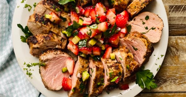 platter with roasted pork tenderloin with a fresh strawberry salsa in the middle