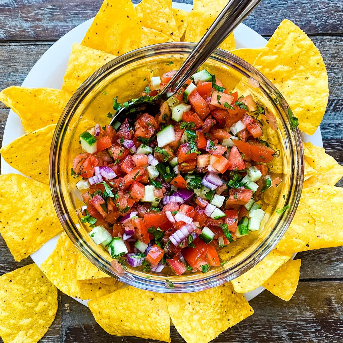 A bowl with chunky salsa with tortilla chips.
