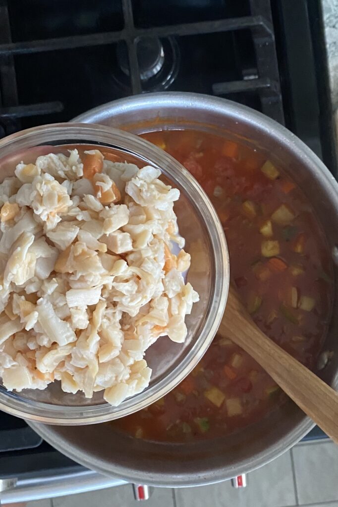 adding clams to a delicious Manhattan chowder recipe