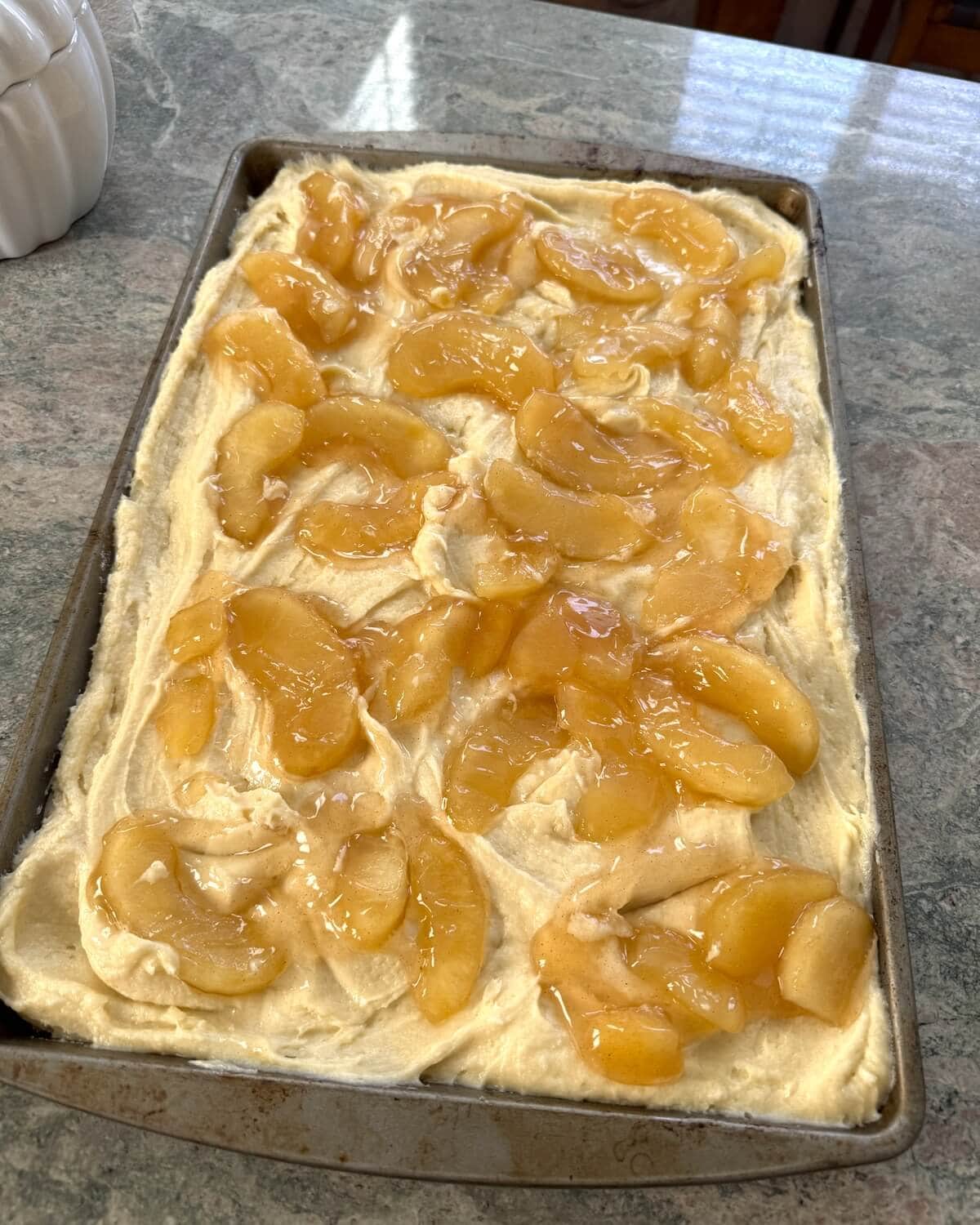 An unbaked sheet pan breakfast cake with apple pie filling.