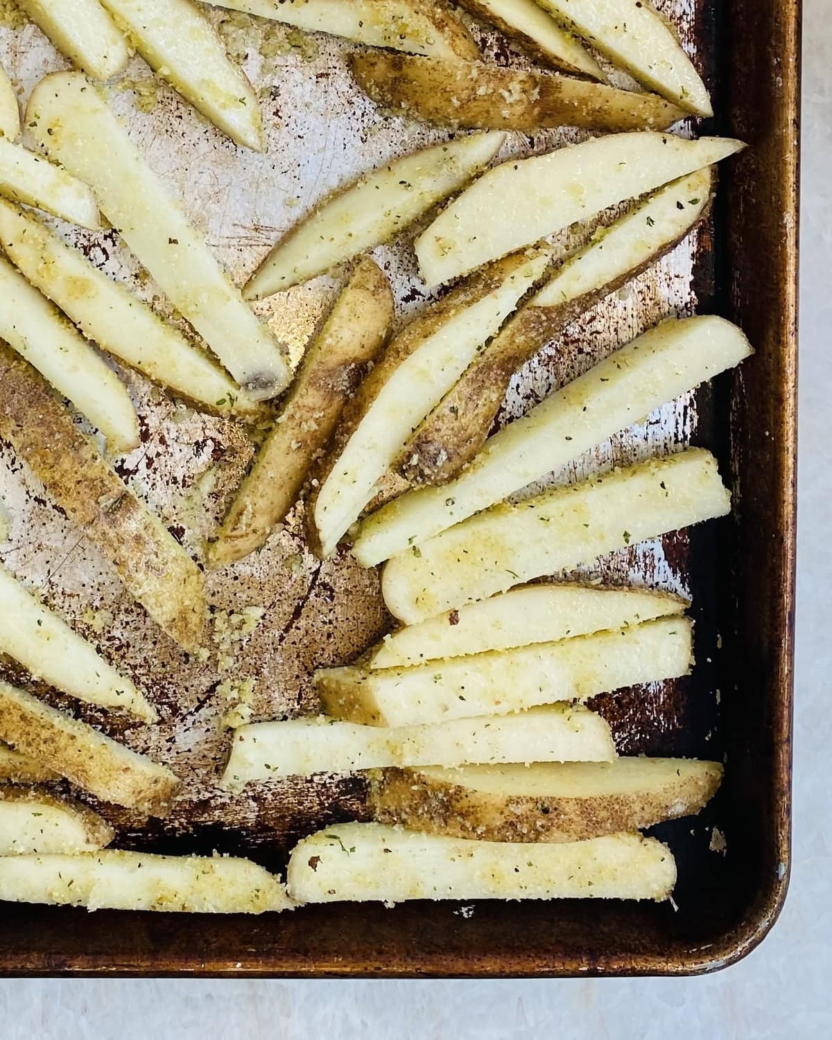 Baking sheet with uncooked oven French fries.