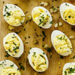 Deviled eggs with dill pickles topped with chopped parsley.