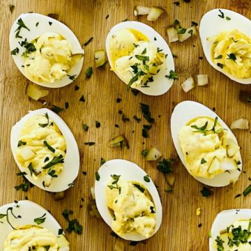 Deviled eggs with dill pickles topped with chopped parsley.