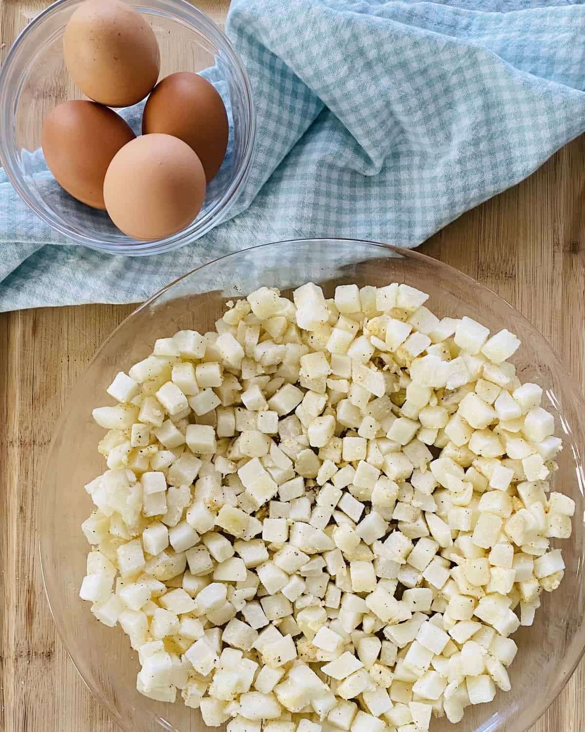 Hash browns in a pie plate and 4 eggs in a bowl.