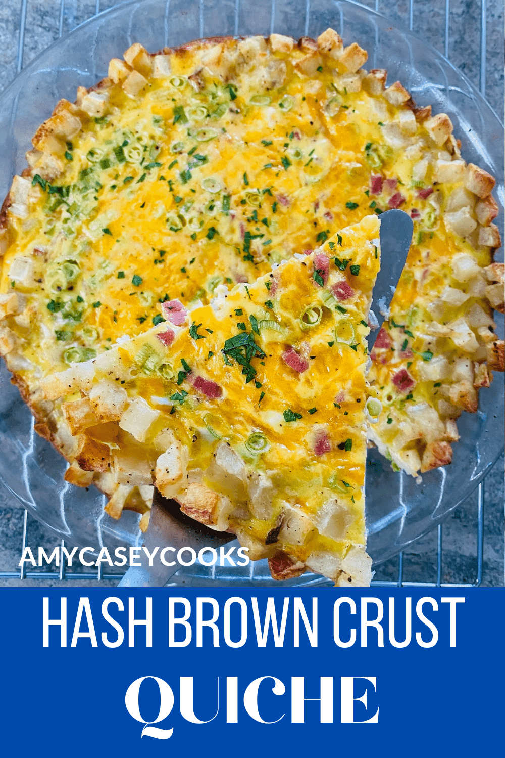 A slice of ham and cheddar quiche on a spatula.