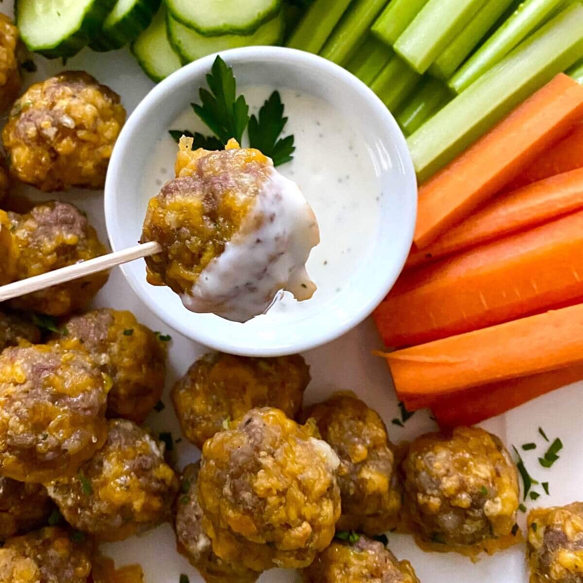 Sausage and cheese balls with dip, carrots and celery.