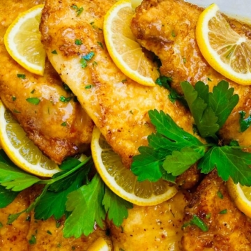 lemon chicken with lemon slices and parsley.