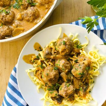 A bowl of meatball stroganoff over noodles.