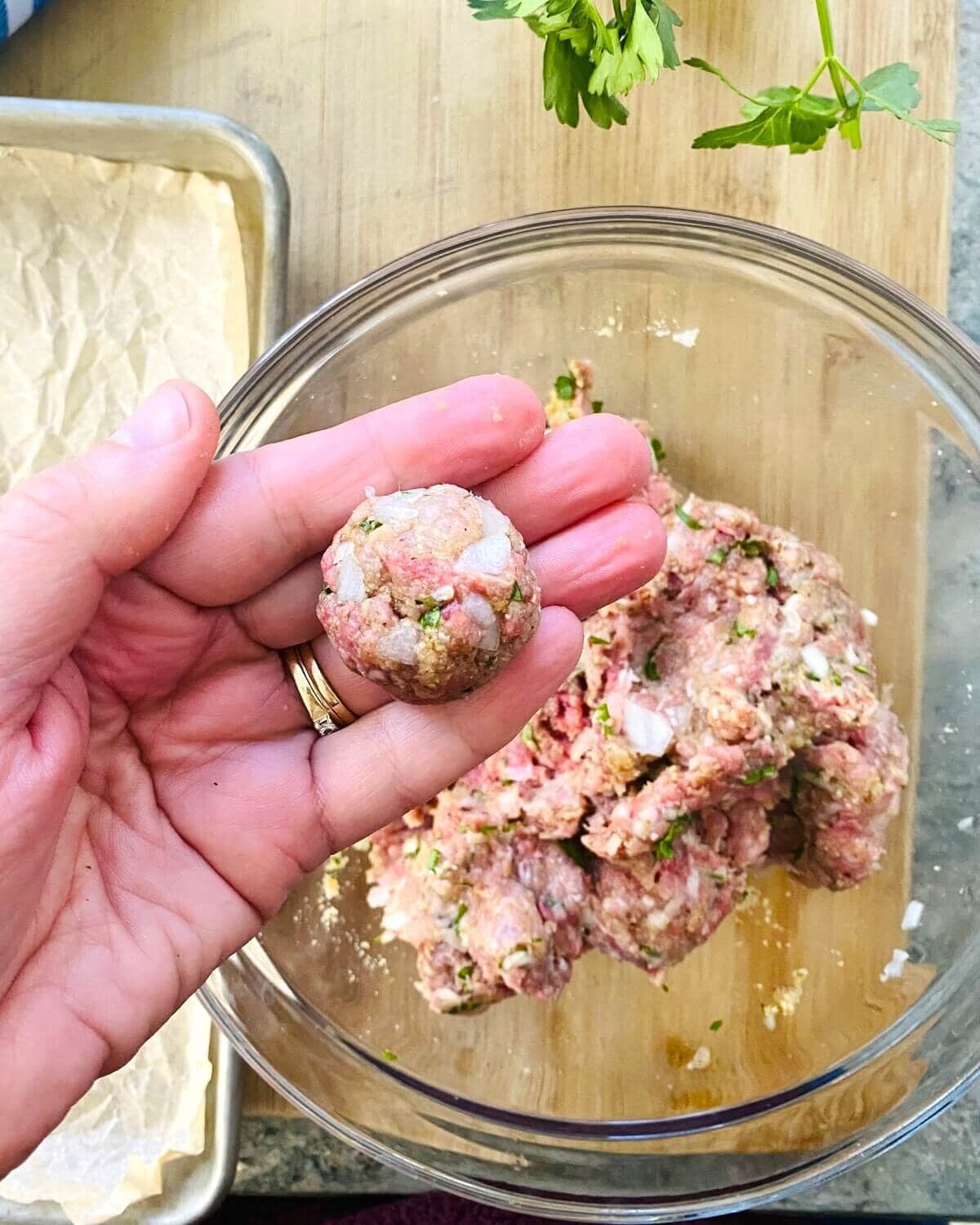 A rolled meatball in a hand.