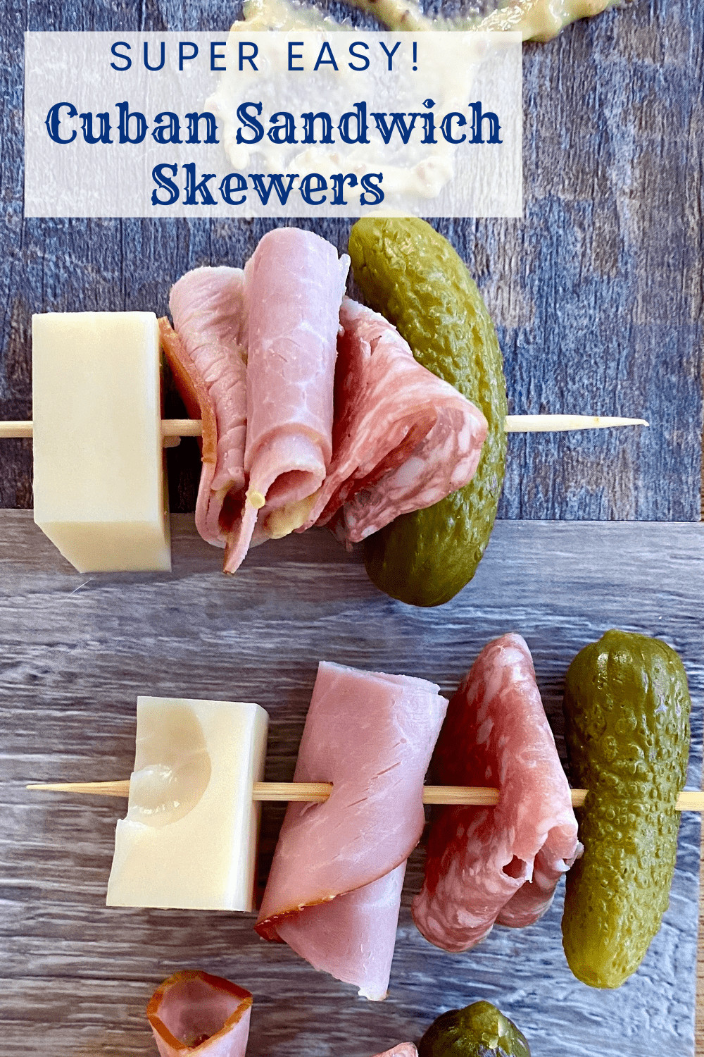 2 skewers with ham, Swiss cheese, salami, and a mini dill pickle.