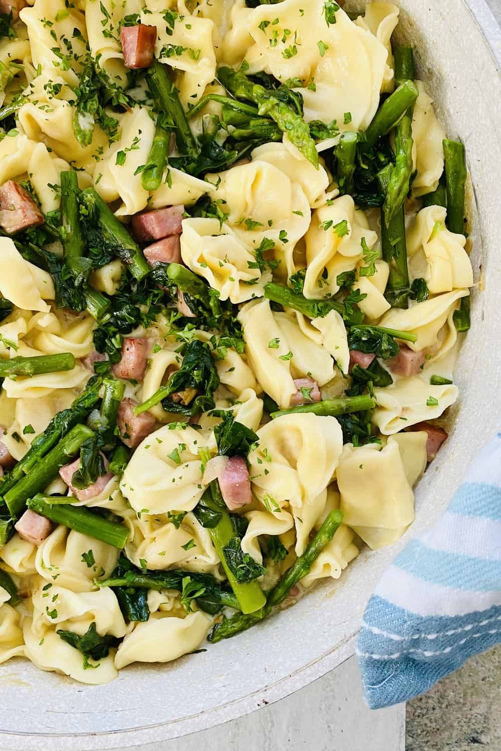 cheese tortellini pasta with sauteed ham, asparagus and spinach
