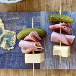 2 Cuban sandwich appetizers on a wood board.