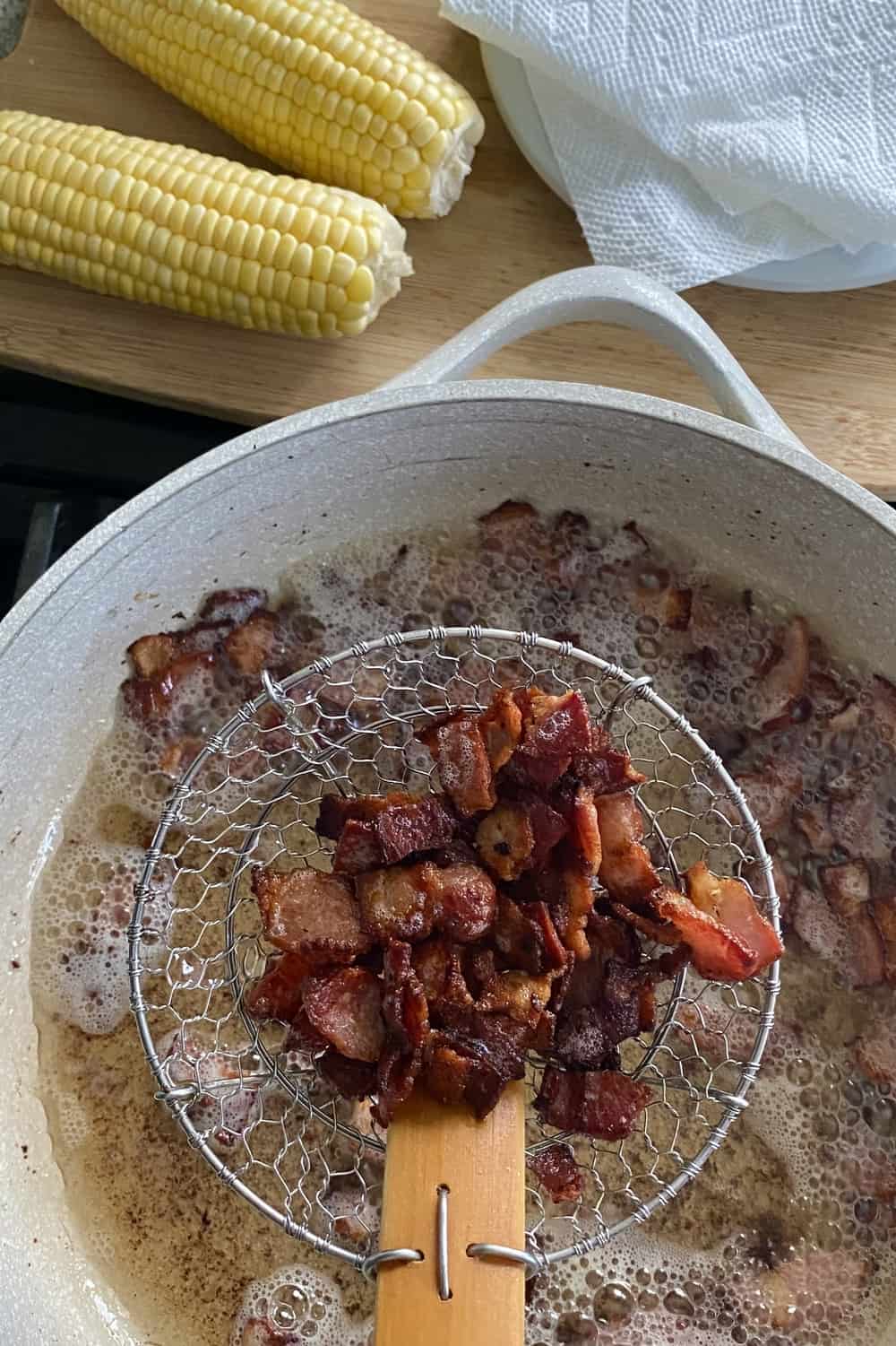 Cooked bacon in a strainer basket.