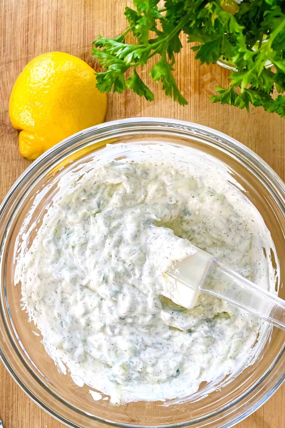 tzatziki sauce in a bowl with a rubber spatula.