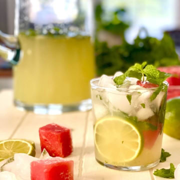 A vodka limeade in a glass and in a pitcher.