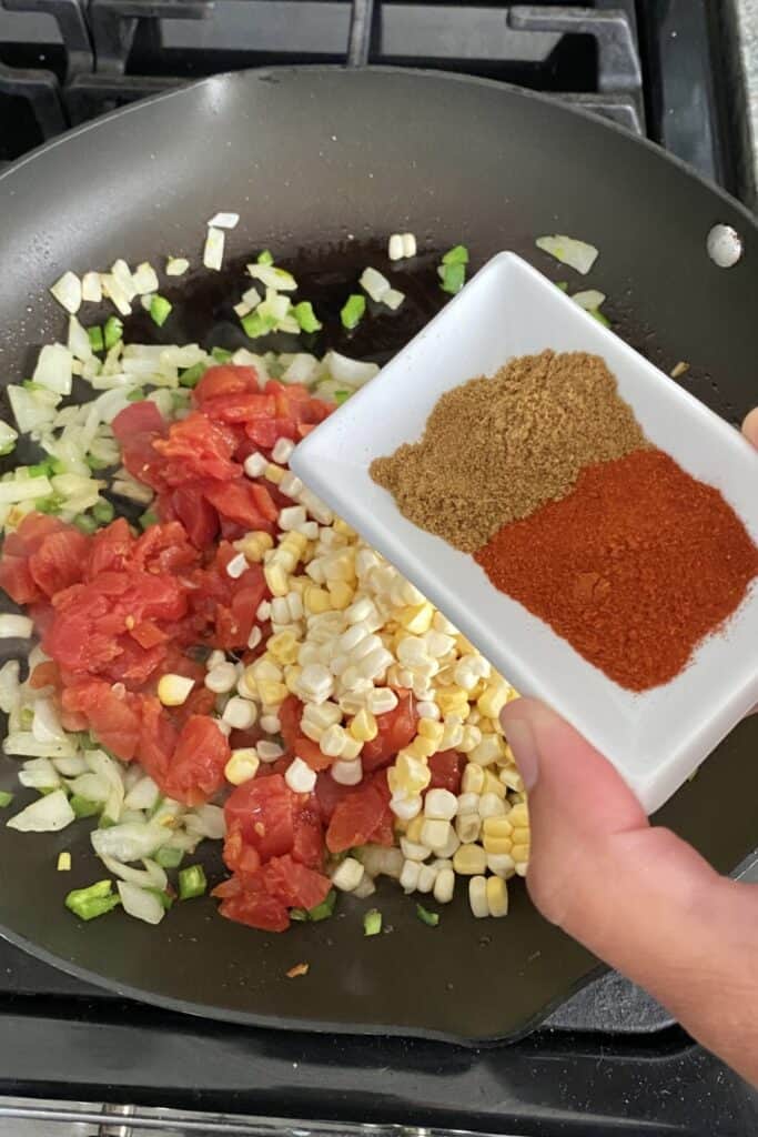 adding spices to vegetable sauté