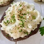 One stuffed mushroom on a board.