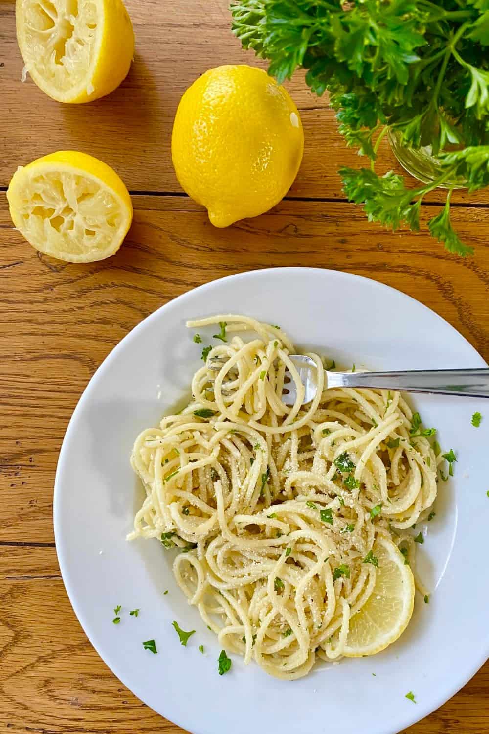 bowl of buttered noodles with Parmesan, lemons and parsley