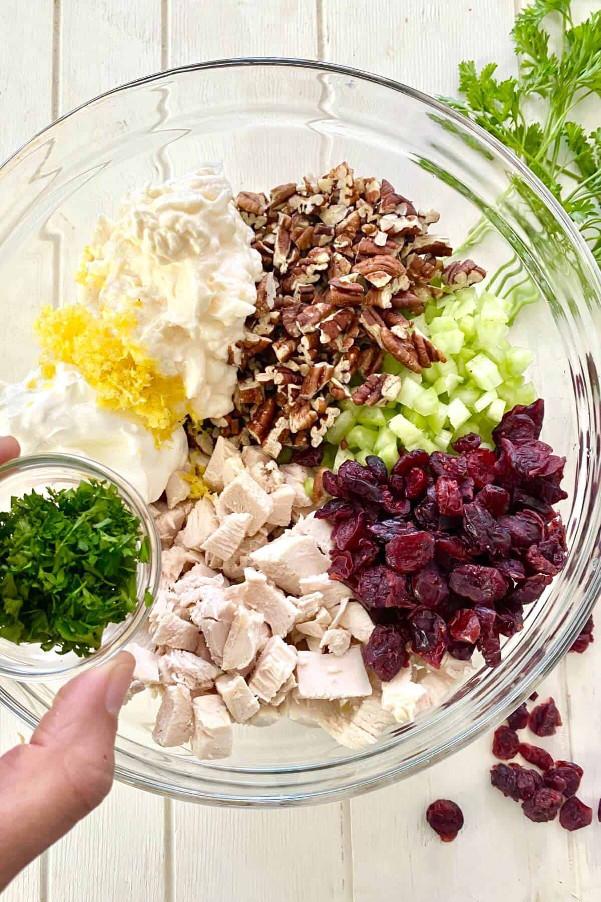 glass bowl with ingredients for cranberry chicken salad.