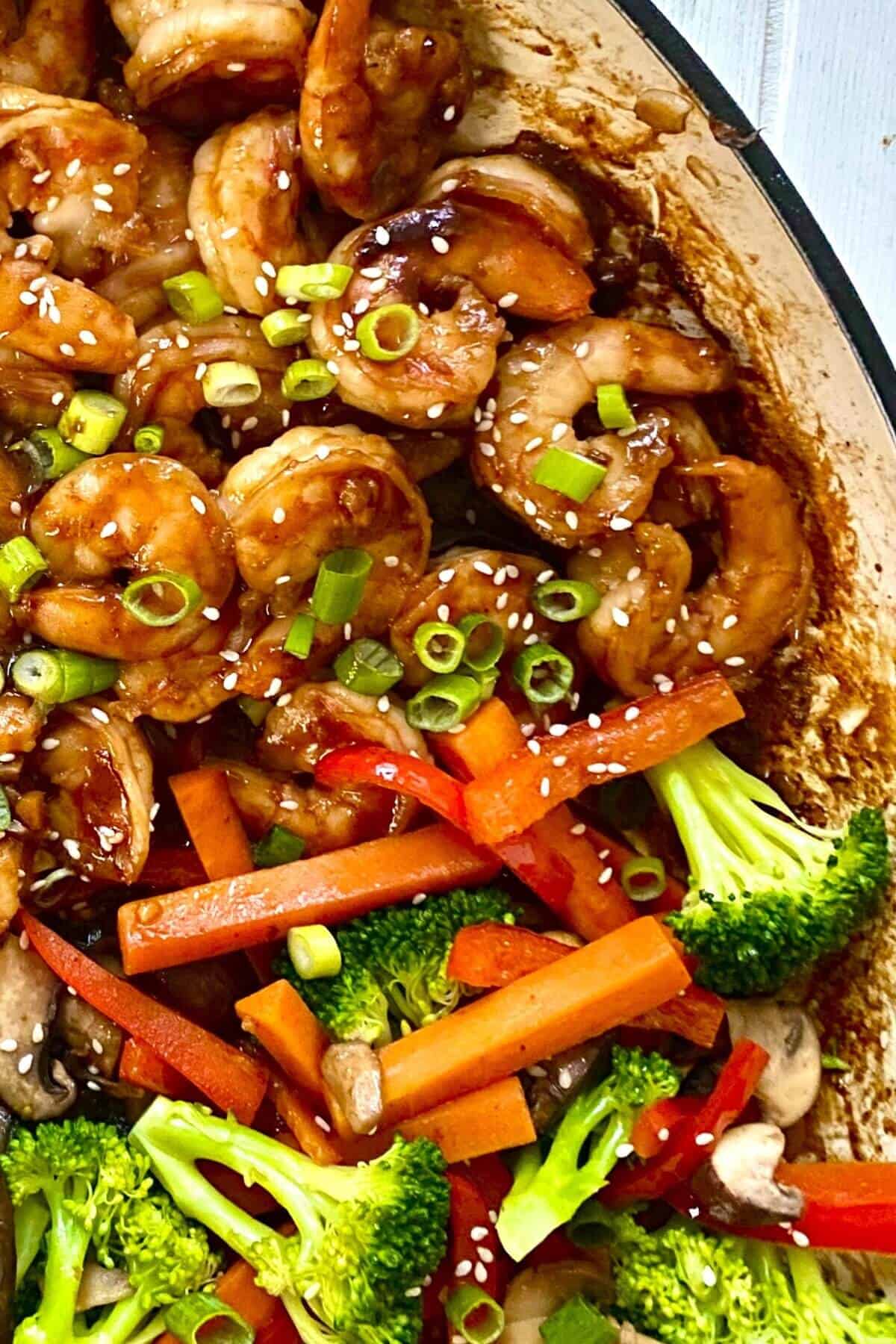 hibachi shrimp, mushrooms, broccoli and carrots in a pan.