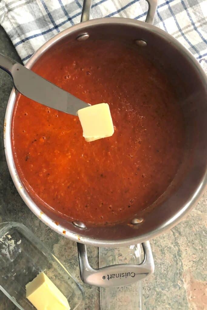 Adding a pat of butter to tomato bisque.
