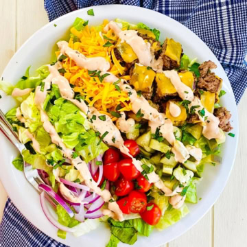 A Big Mac Bowl cheeseburger salad with a blue napkin.