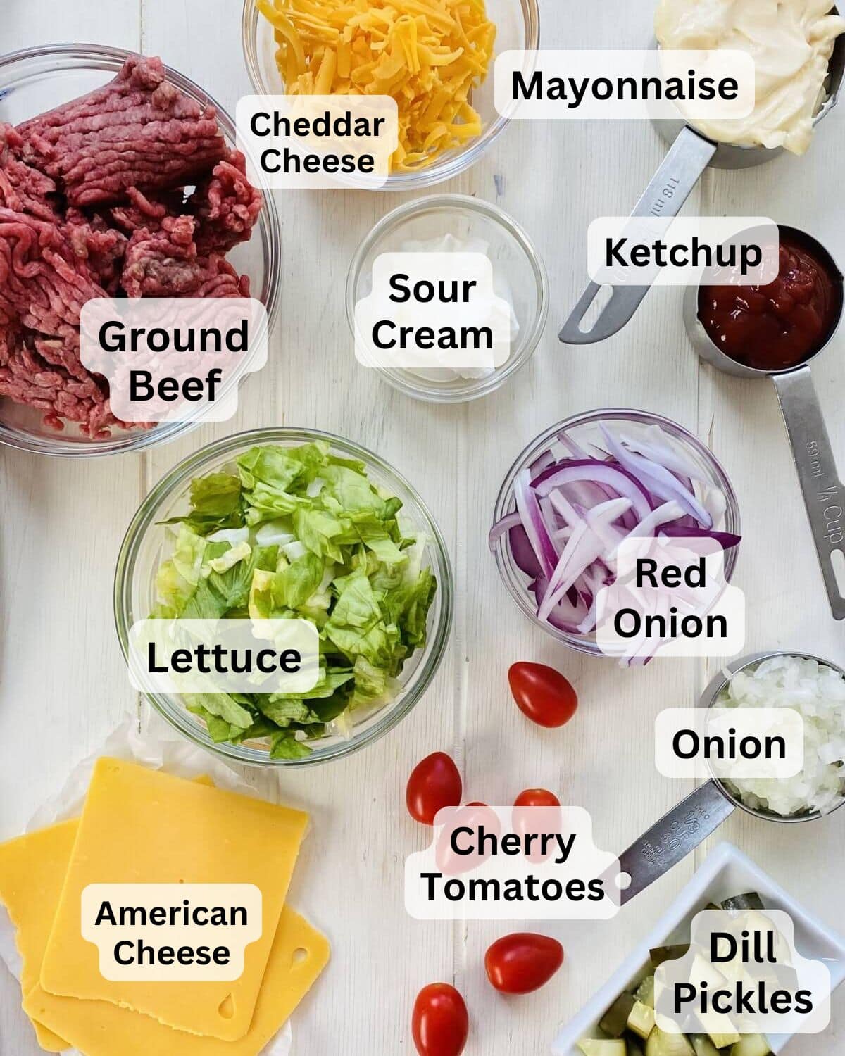 Ingredients for Bic Mac bowls including ground beef, onion, American cheese, cherry tomatoes, lettuce and dill pickles.