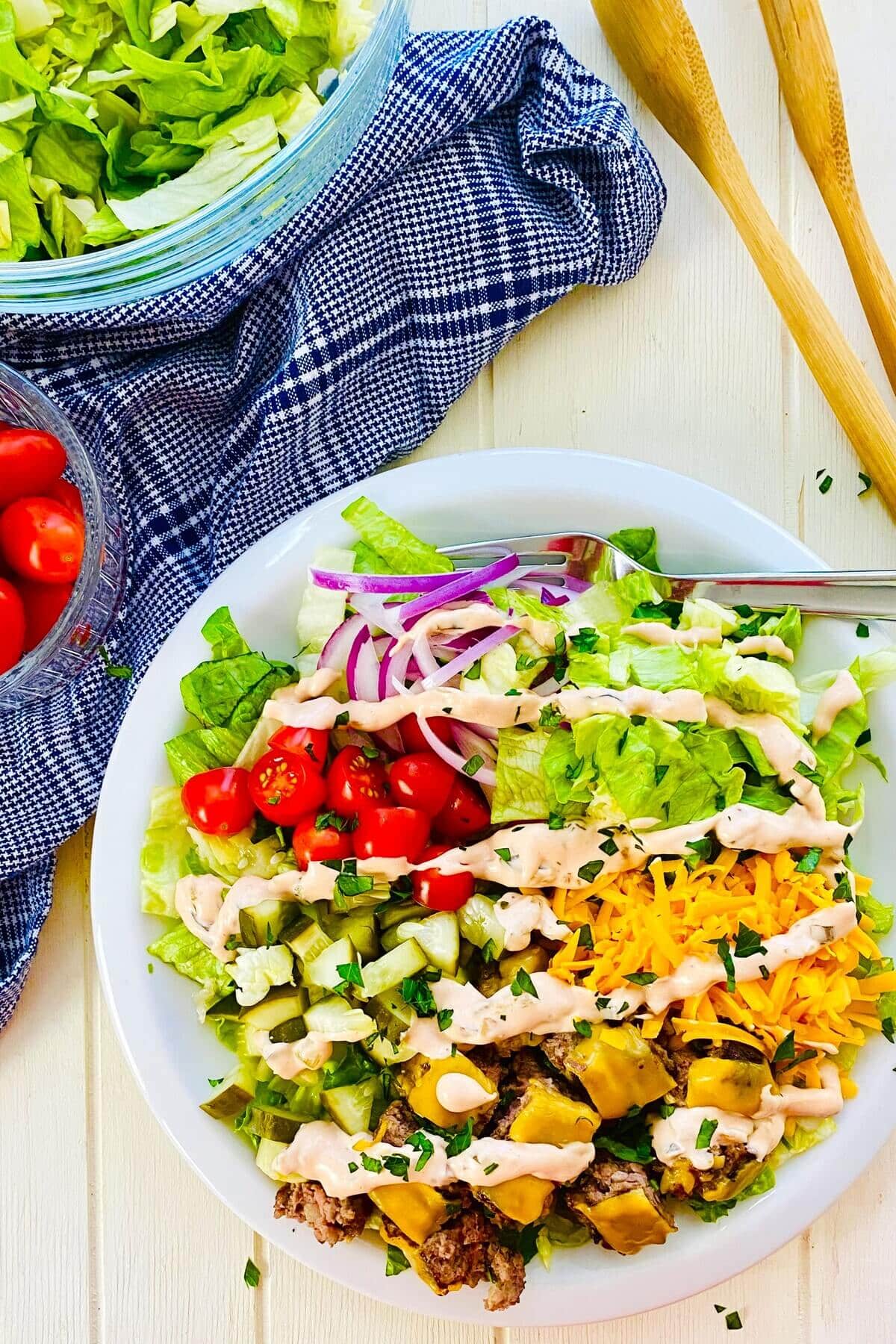 An assembled Big Mac salad bowl with special sauce dressing.