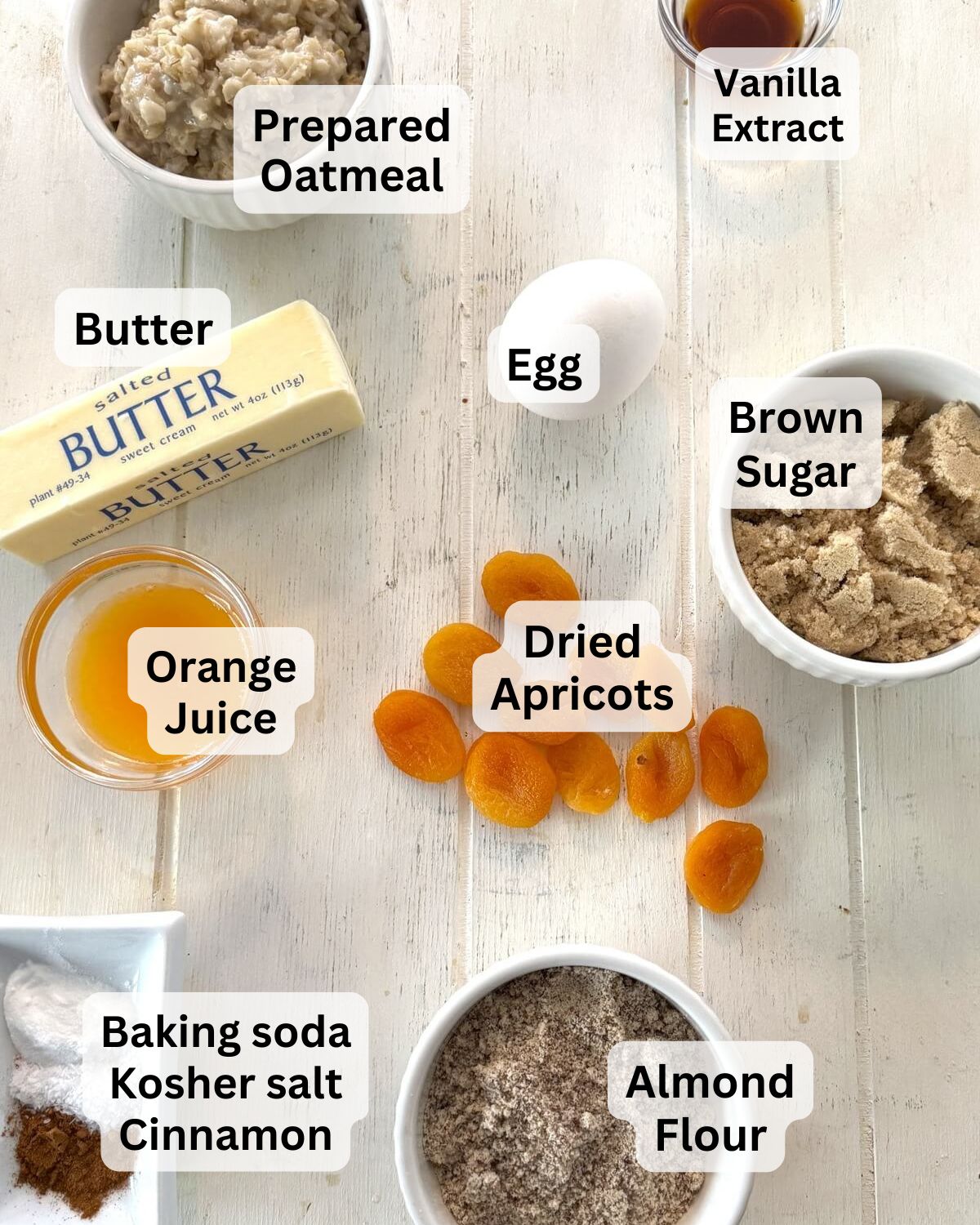 Oatmea;, apricots, egg, brown sugar, almond flour, butter on a board.