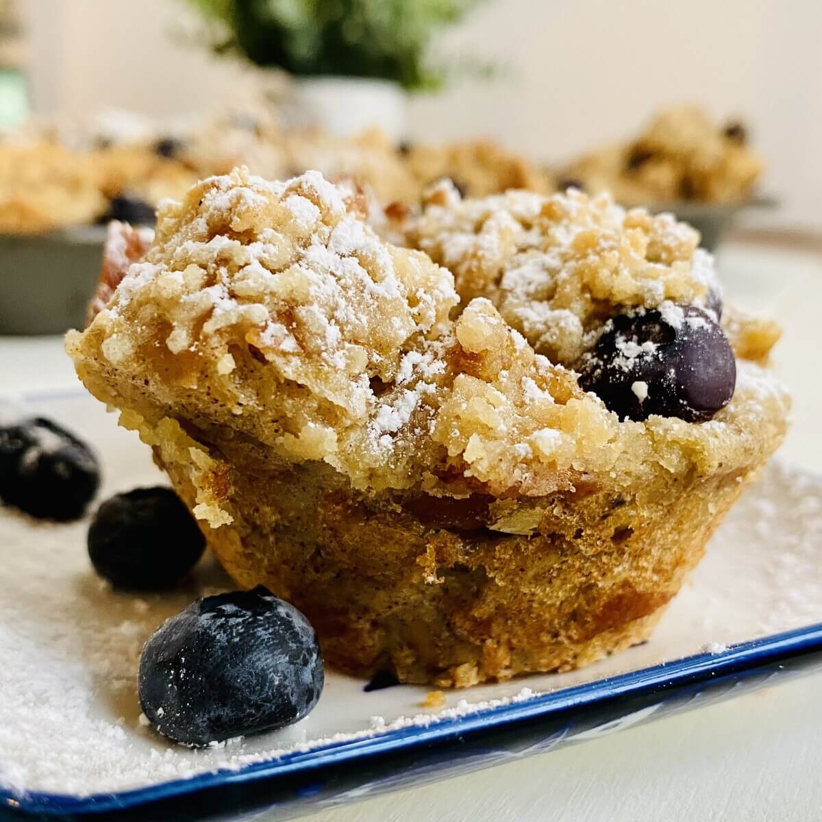 a powdered sugar topped French toast muffin with blueberries.