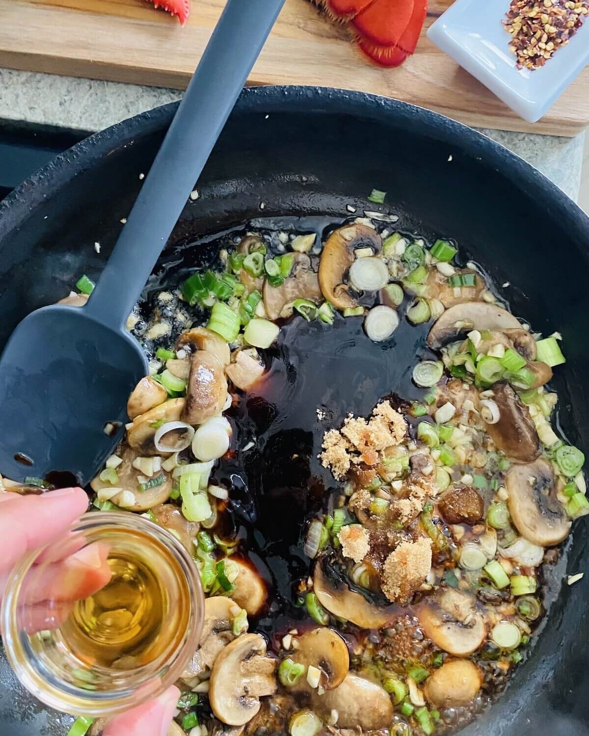 adding, oyster sauce, sesame oil, brown sugar, and red pepper flakes to stir fry.