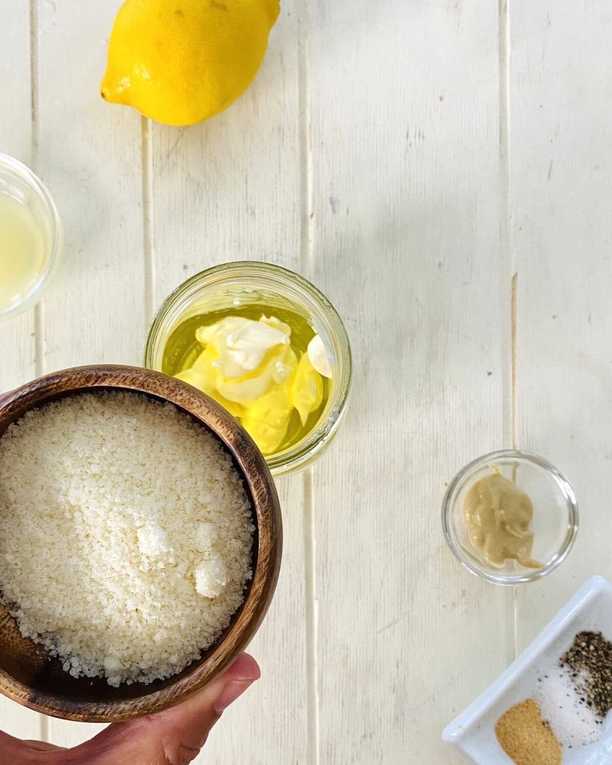 Adding parmesan to Caesar dressing.